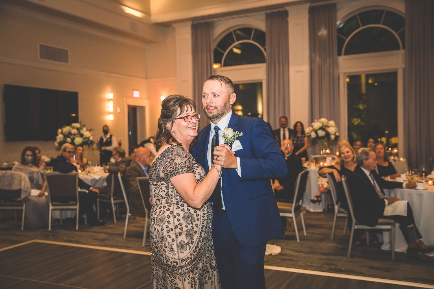 Wedding reception dance in grand ballroom with classical architectural details.