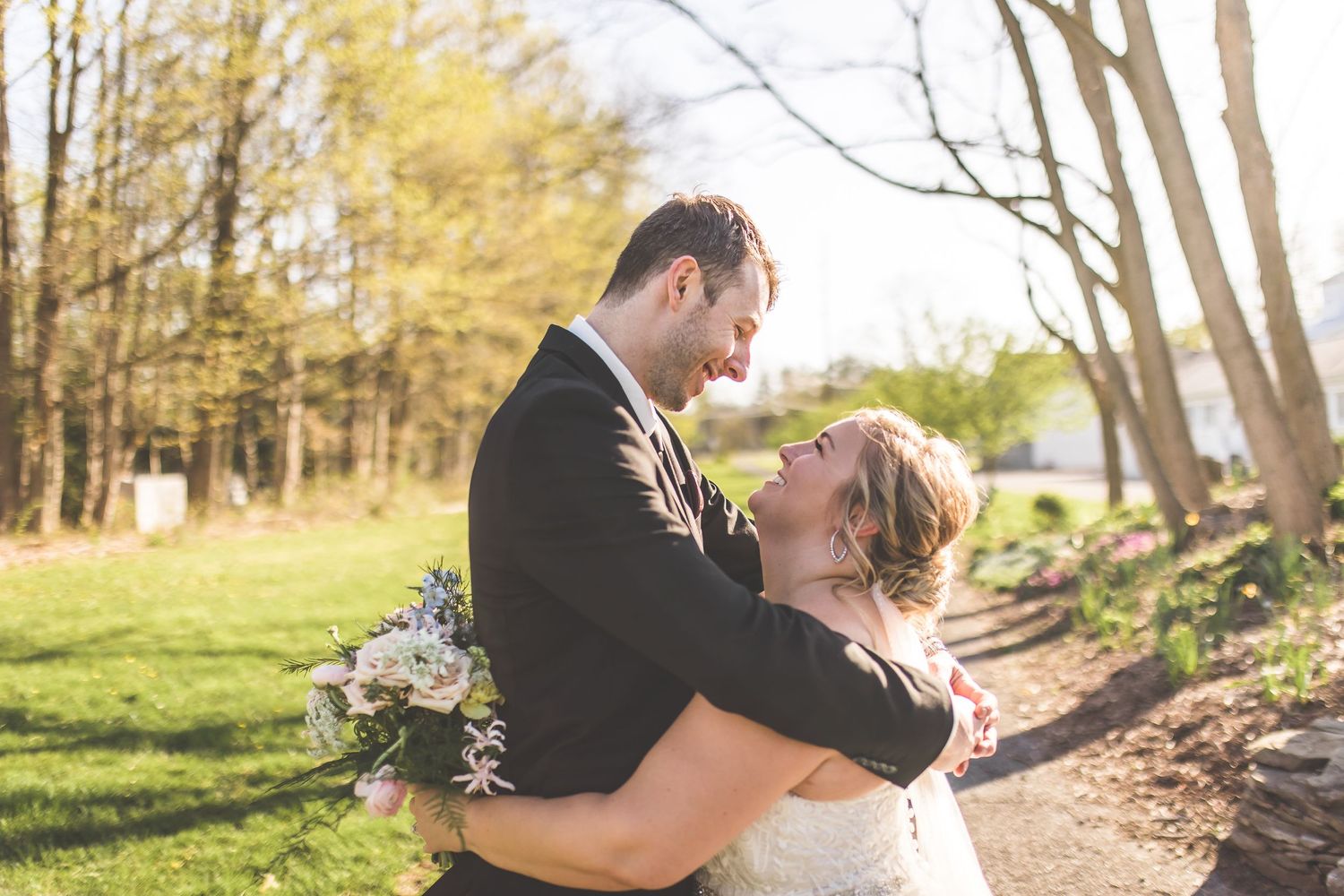 Romantic wedding portraits captured in natural outdoor setting with golden sunlight.