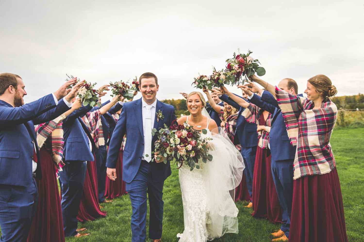 Wedding party cheers and celebrates during outdoor group photos.