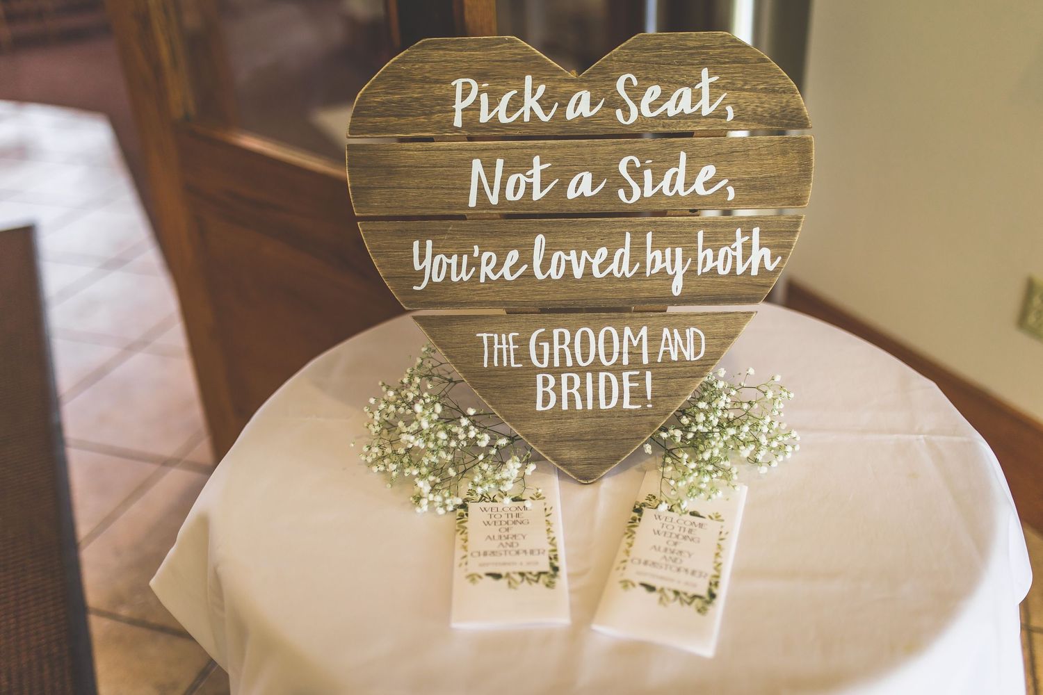 Rustic wooden wedding signs with white lettering and floral accents.
