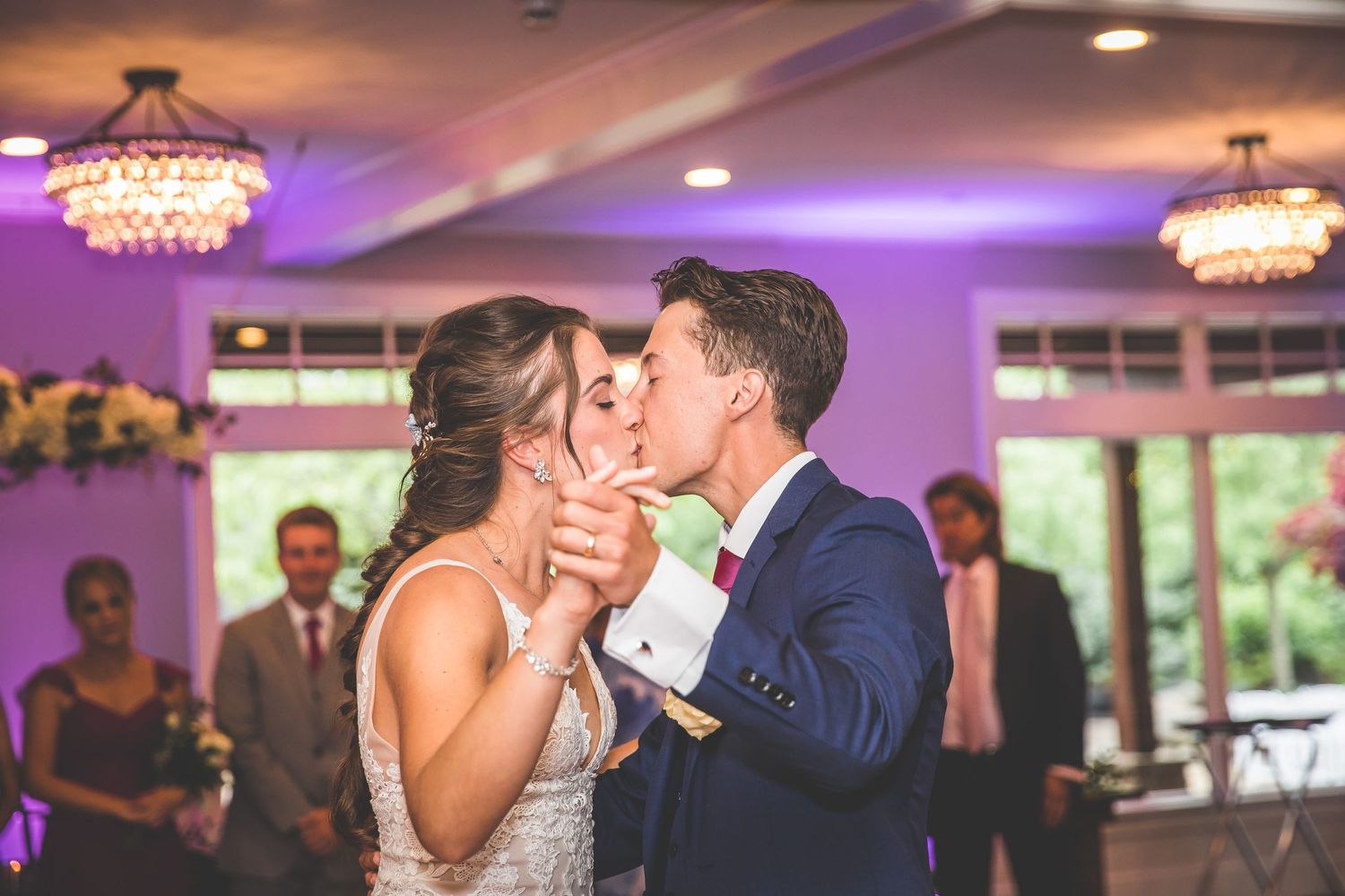 Couple sharing romantic dance moments during their wedding reception in a beautifully lit ballroom.