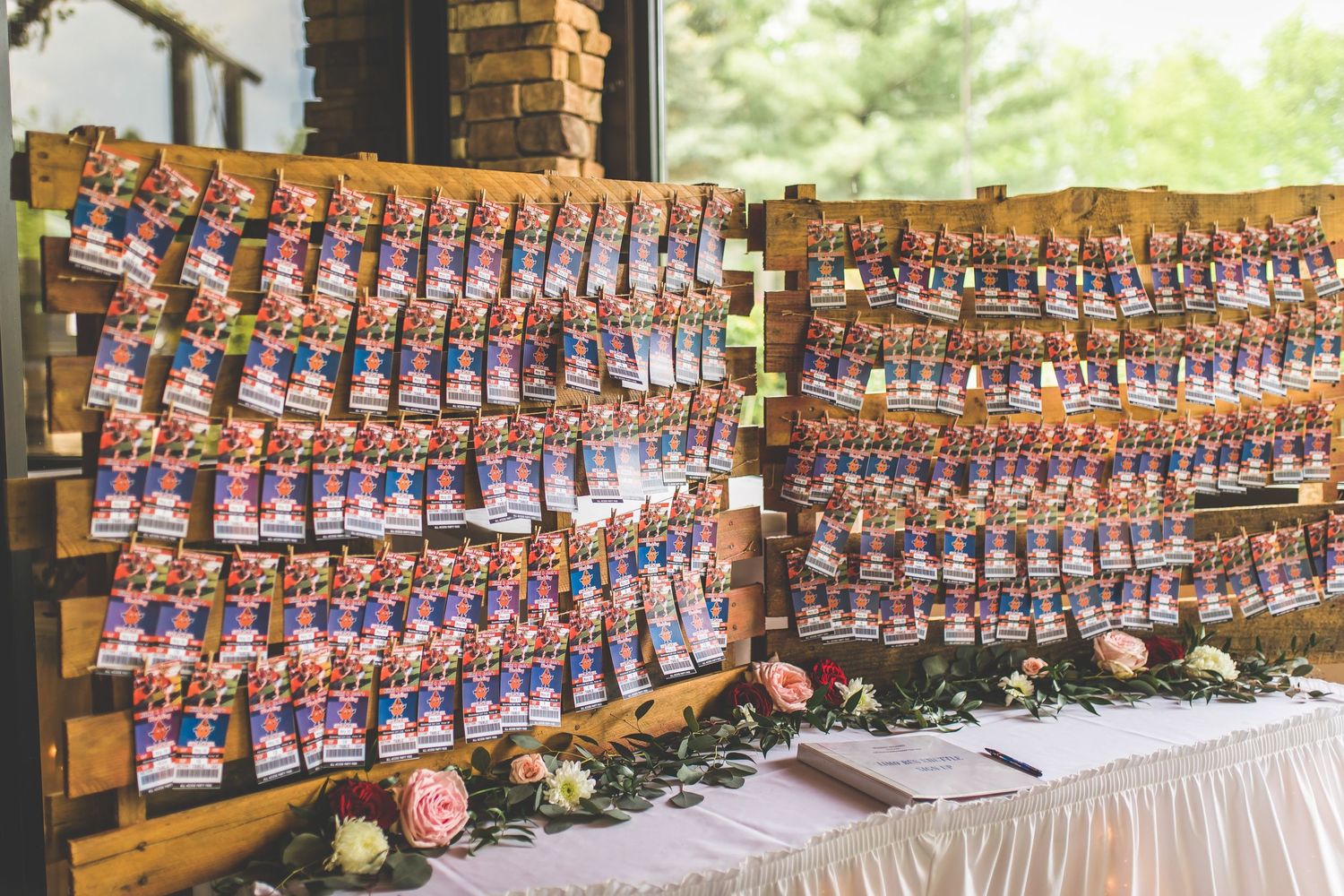 Wedding favors arranged in rows on a display table with pink floral decorations.