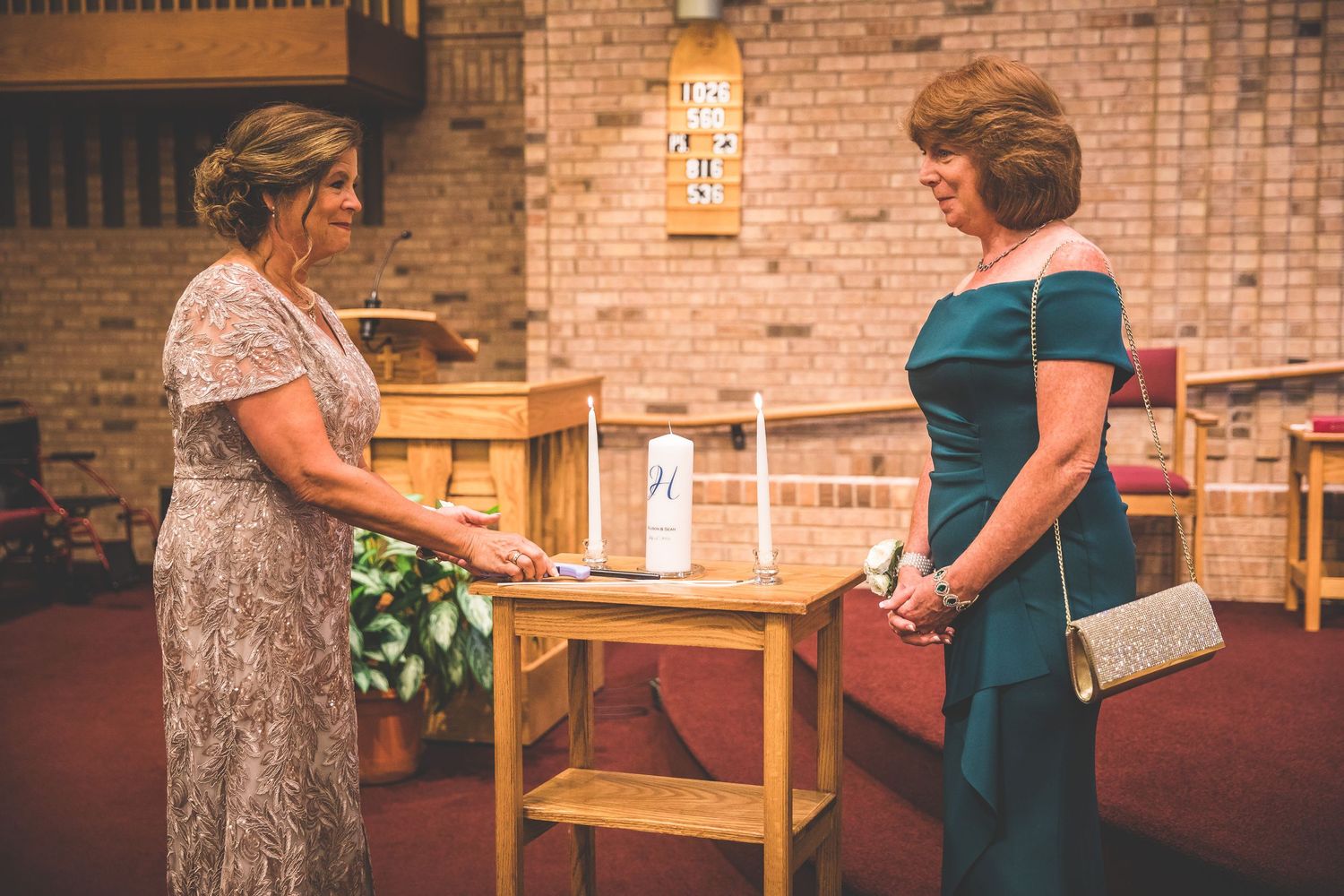Wedding guests mingling in a rustic venue with brick walls and wooden furniture.