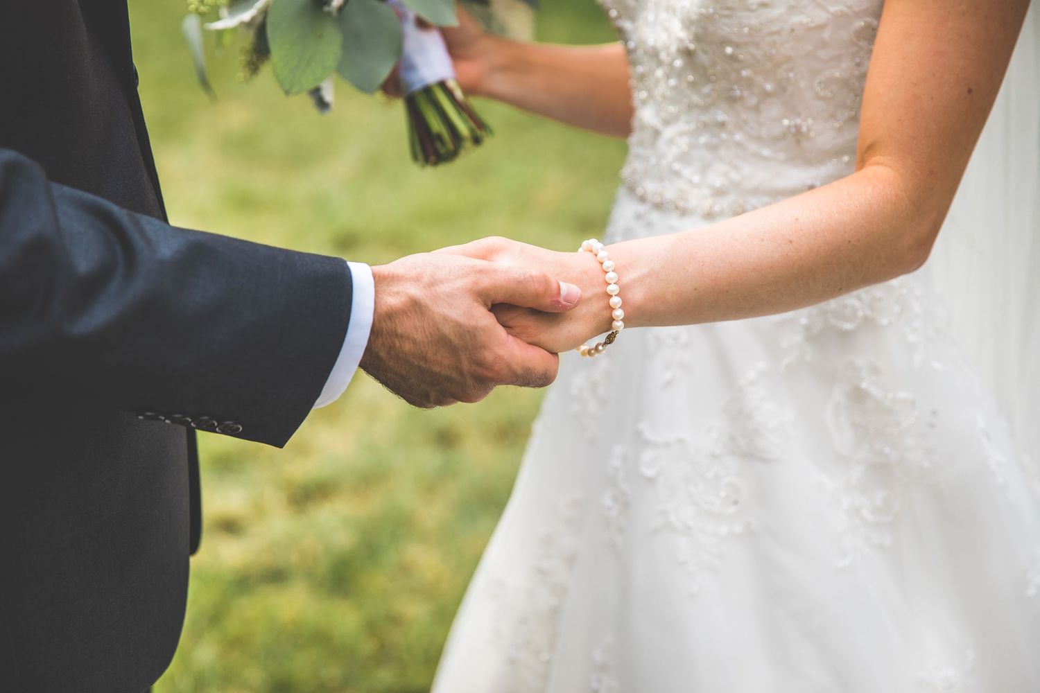 Close-up shots of wedding rings being exchanged during an outdoor ceremony in natural sunlight.