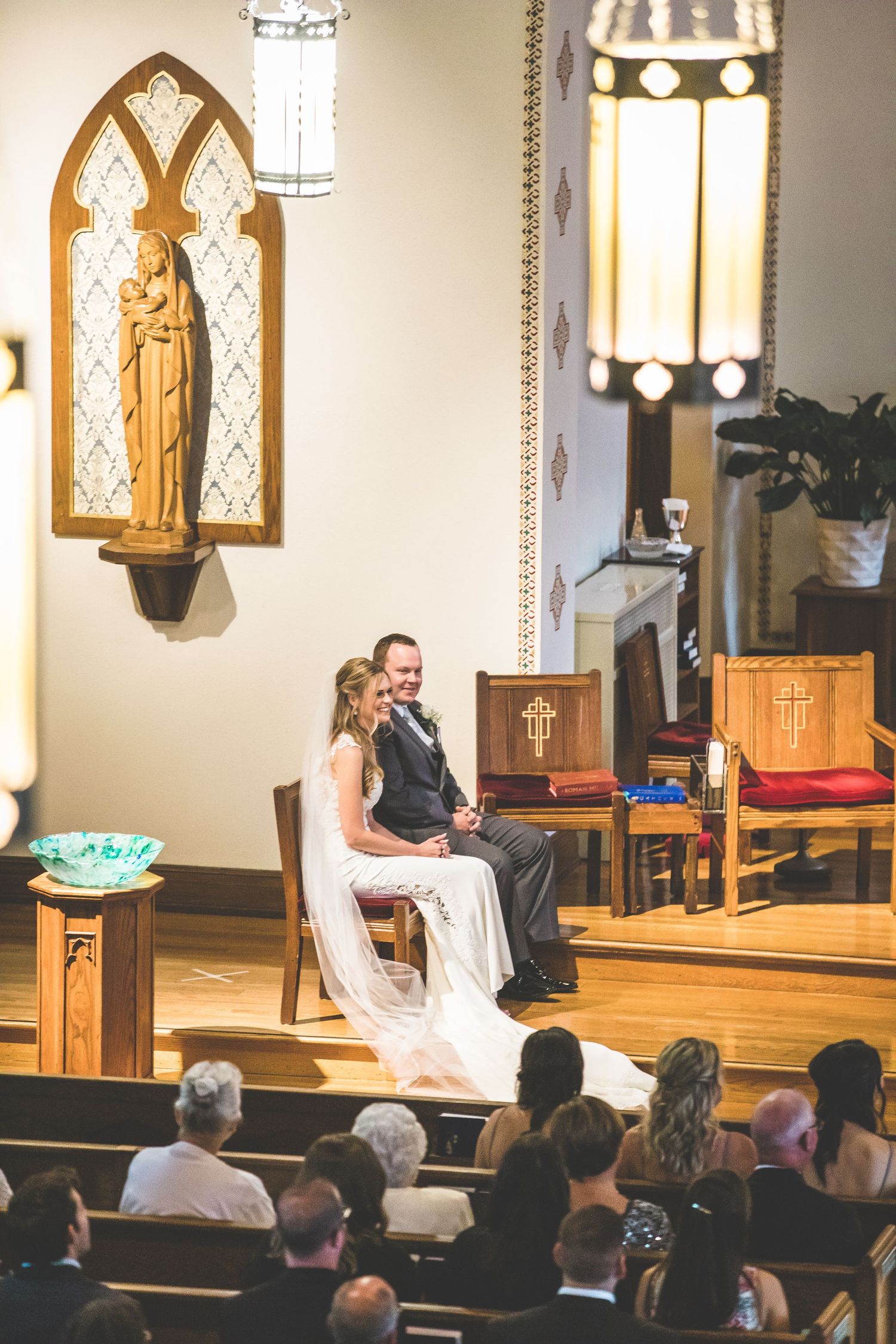 A wedding ceremony takes place in a traditional church sanctuary with gothic architectural details.