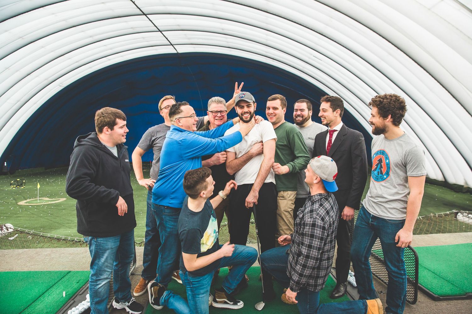 A group of people having fun and laughing together outdoors at a social gathering.