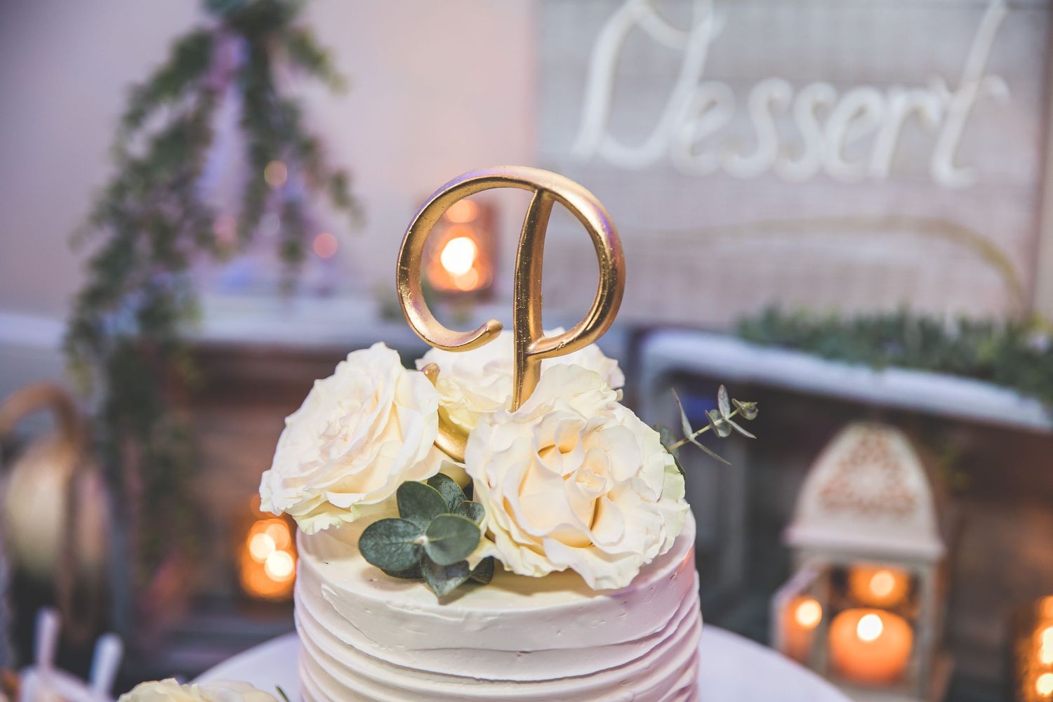 Wedding dessert table with elegant cake and ambient lighting.