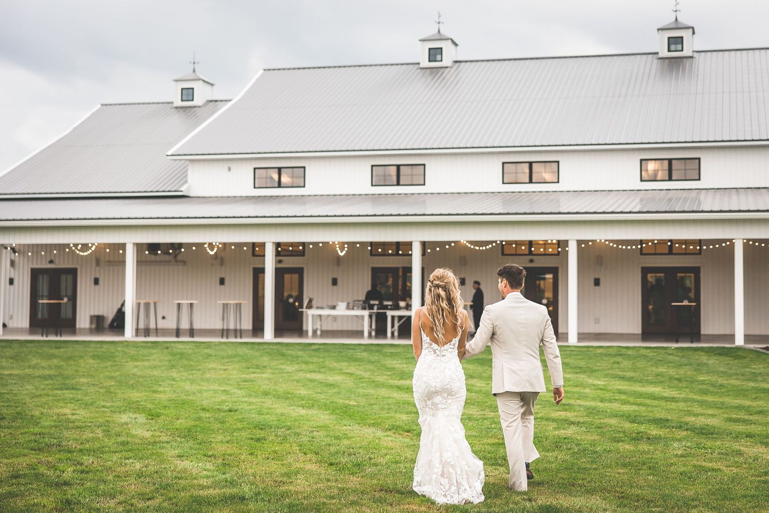 Modern white farmhouse venue with classic architecture and manicured lawn for weddings.