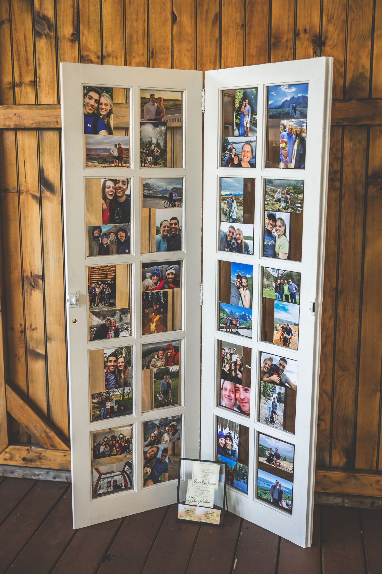Photo display with white window frames showing travel and family memories on wooden wall.