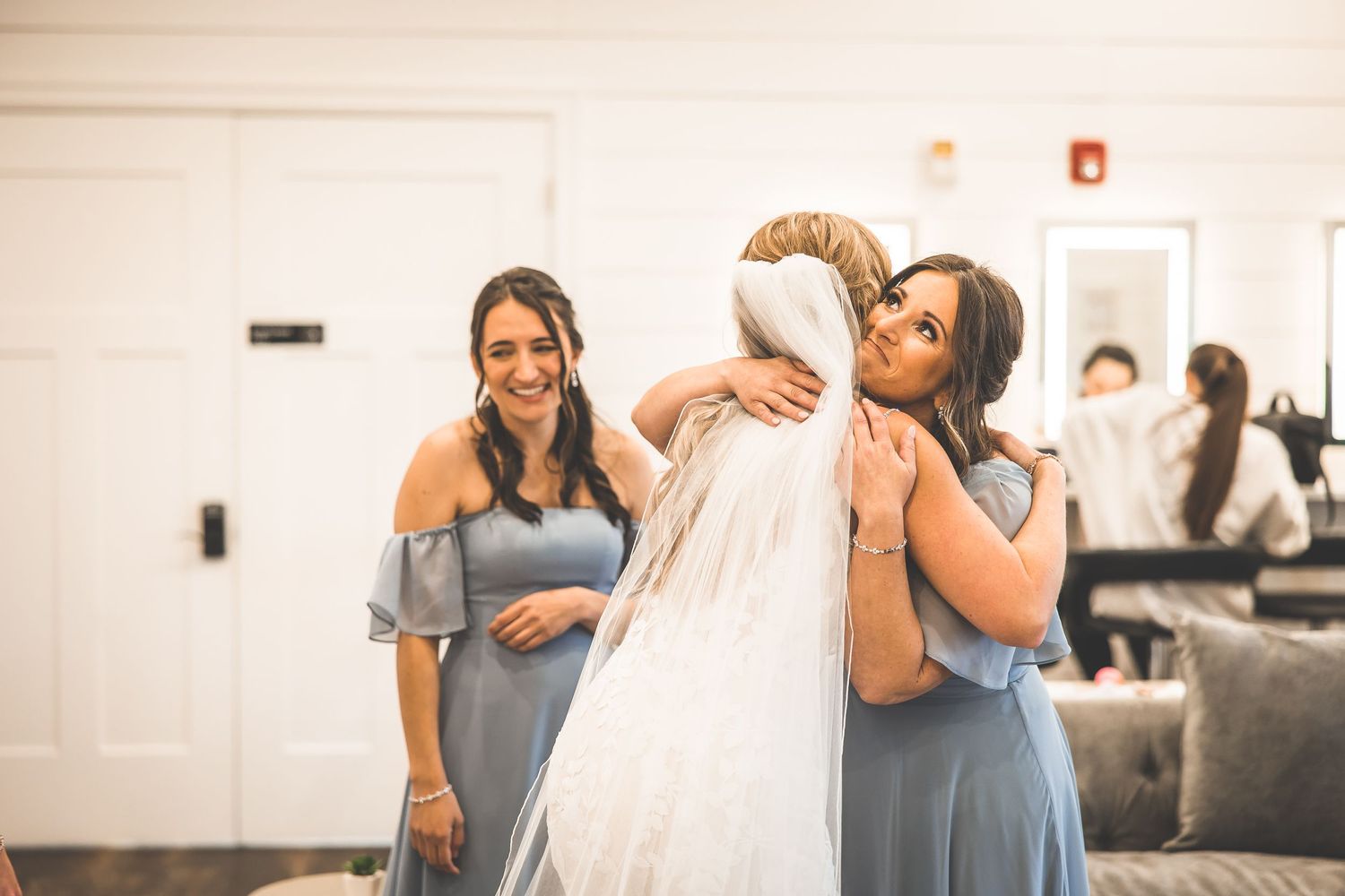 Candid shots of bridesmaids in blue dresses helping with wedding preparations.