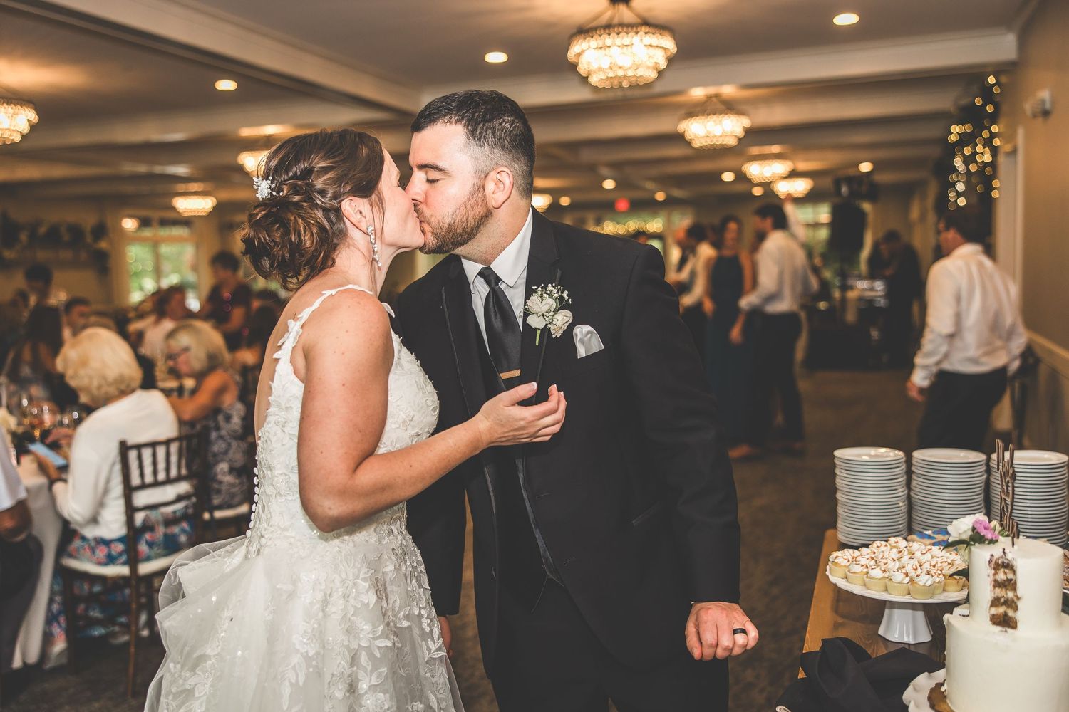 Elegant wedding reception features couple's cake-cutting celebration.