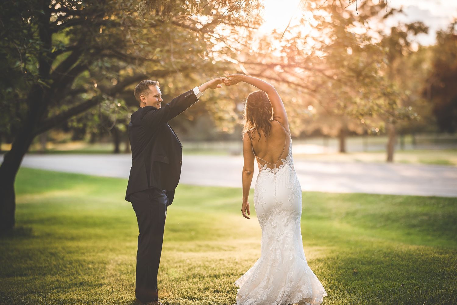 Wedding couple poses for romantic sunset portraits on golf course.