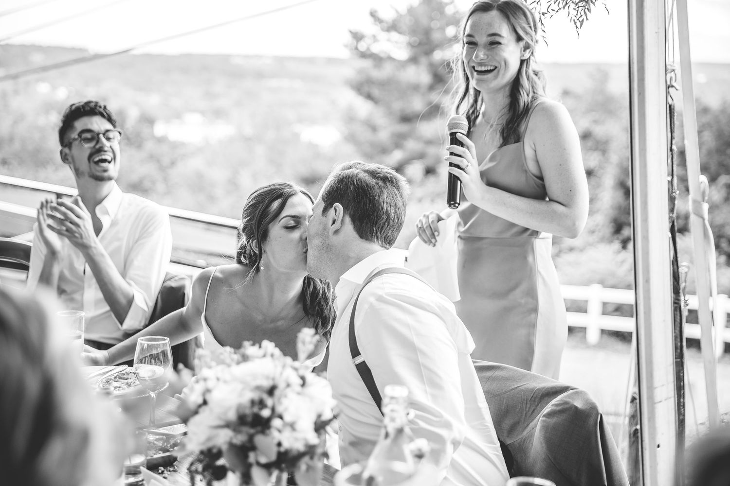 Candid moments of laughter and joy during wedding reception speeches and toasts.