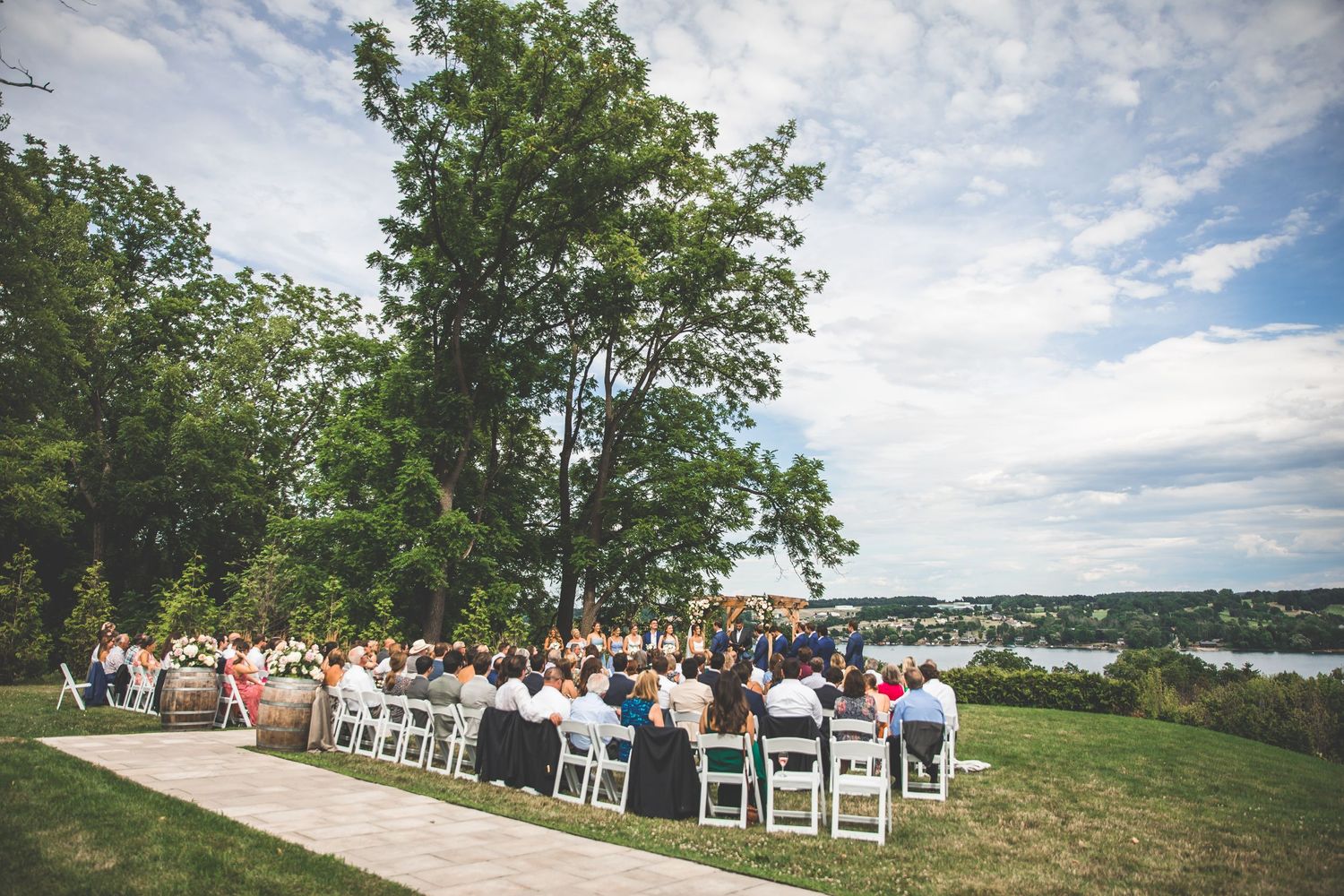 Scenic outdoor wedding setup with white chairs and natural landscape views.