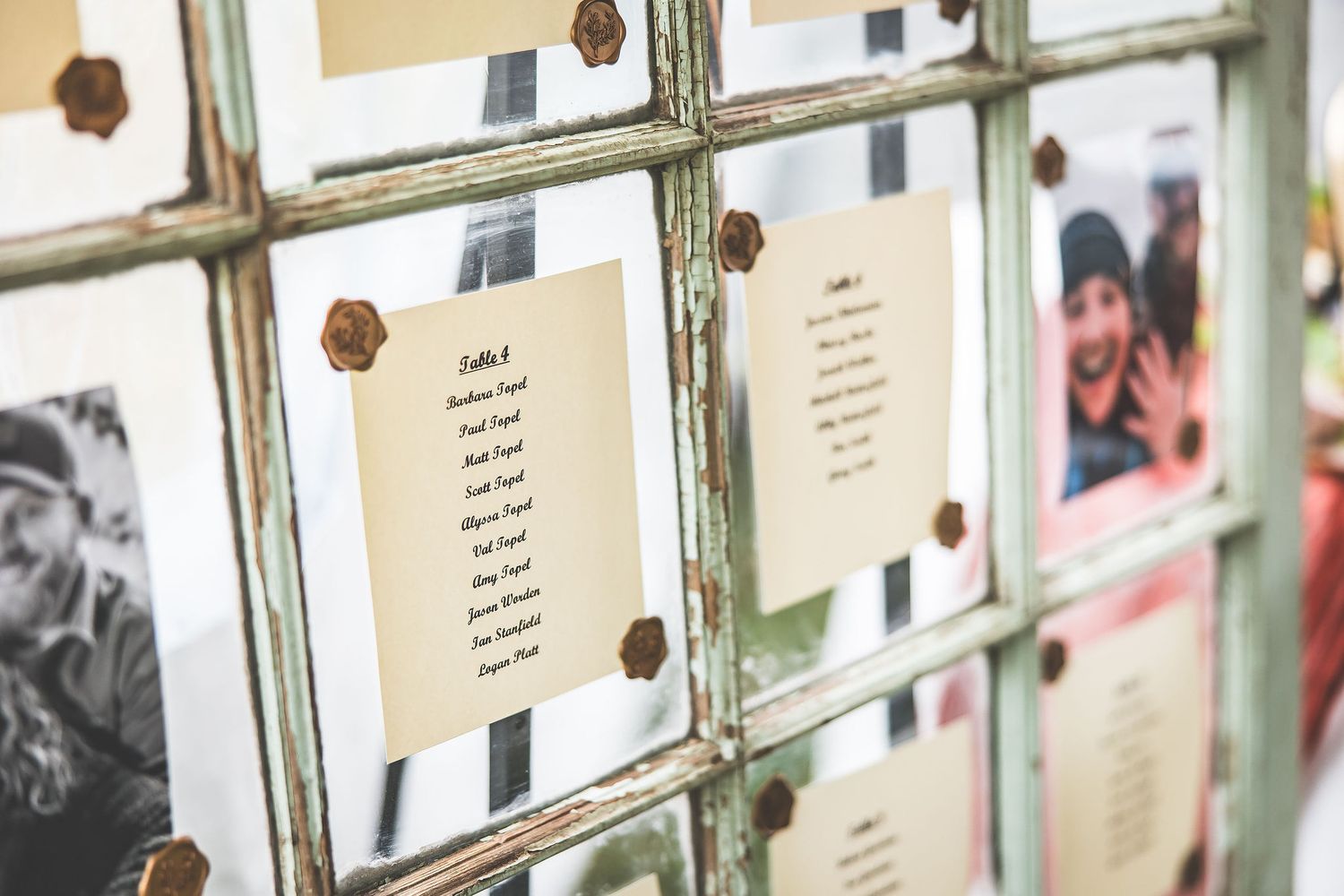 Wedding seating chart displayed on vintage window panes with paper details.