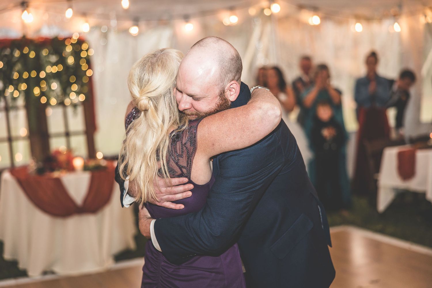 Couples sharing romantic dances during an evening reception under glowing lights.