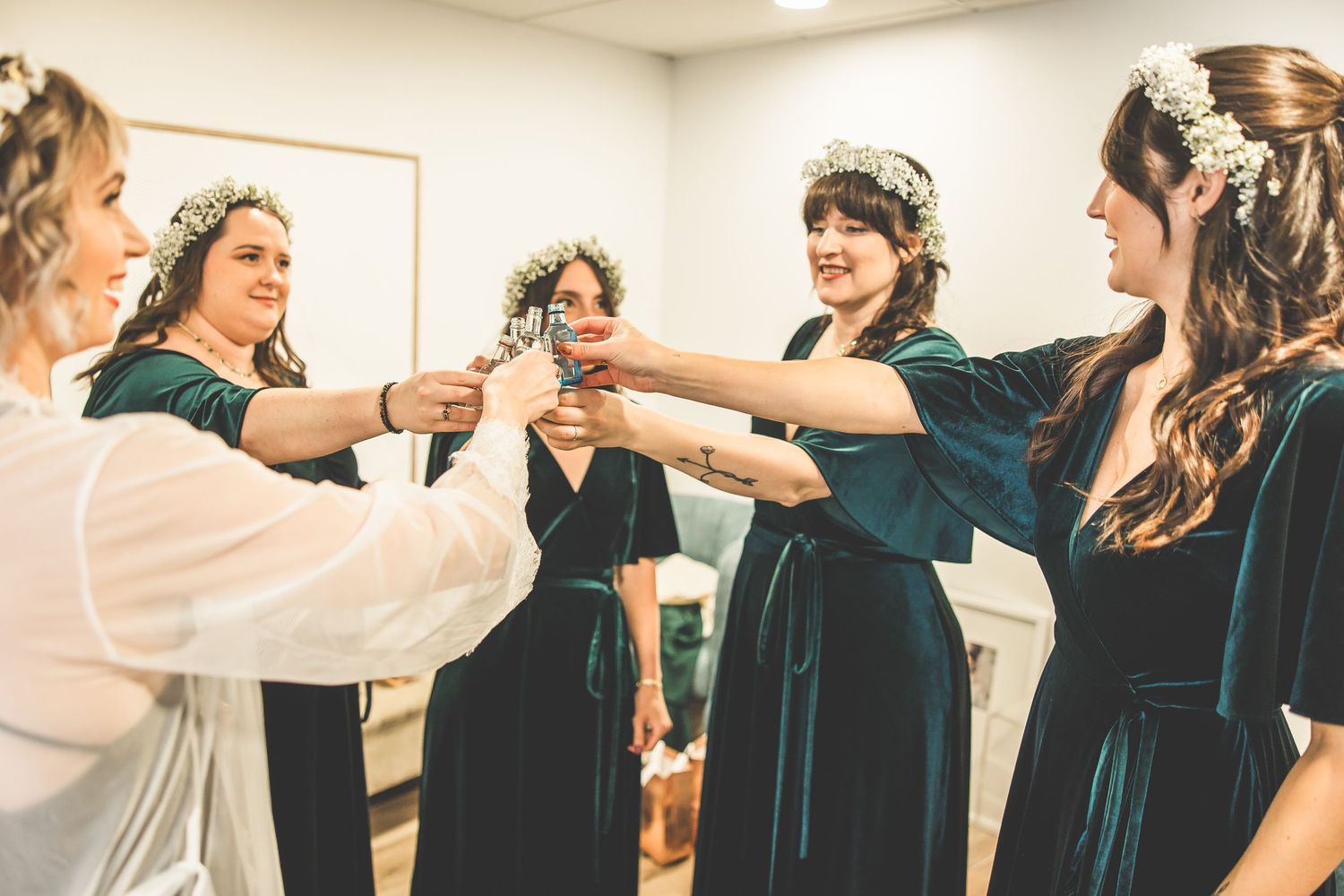 Wedding party celebrating and dancing together in matching teal dresses.