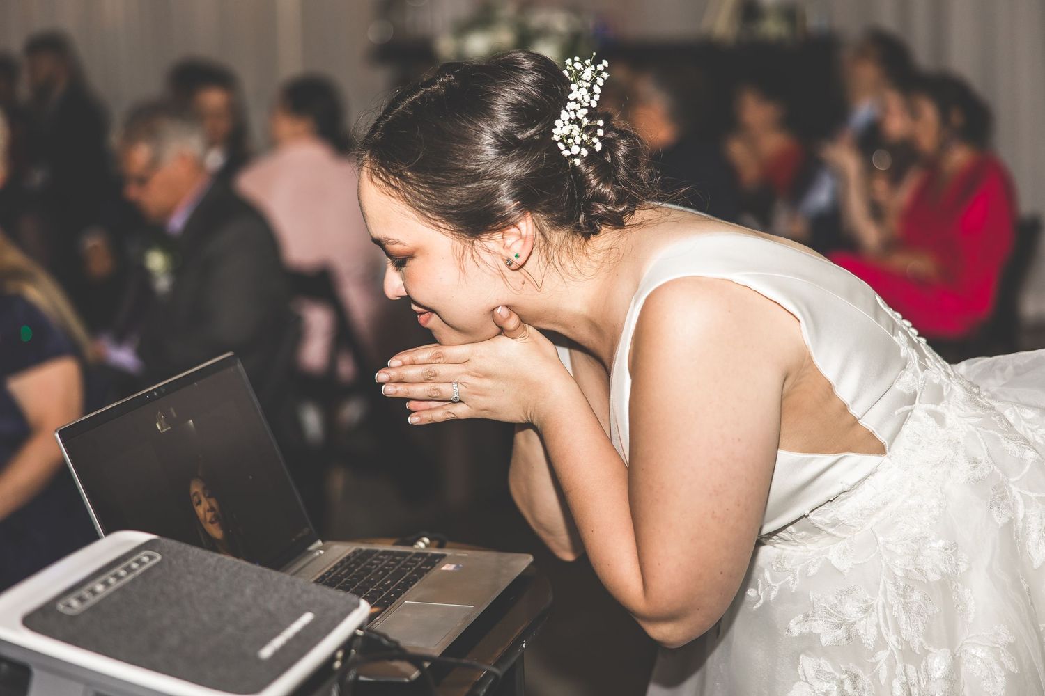 Wedding guests enjoying a celebration in an elegant reception hall with white draping.
