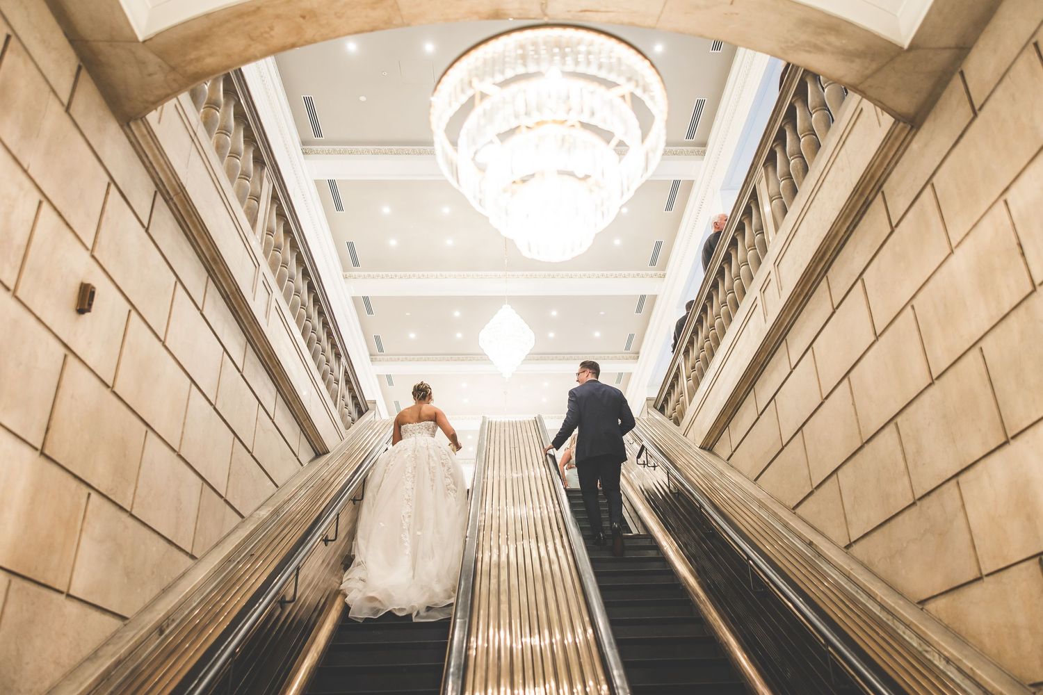 Grand hallway with dramatic lighting and architectural details featuring crystal chandeliers.