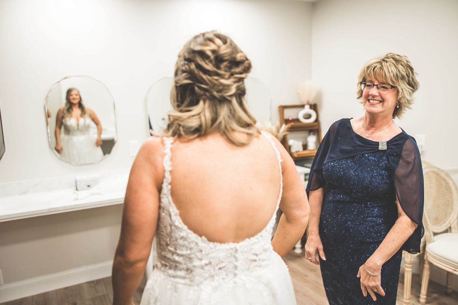 Bride gets final dress adjustments in a getting-ready room.