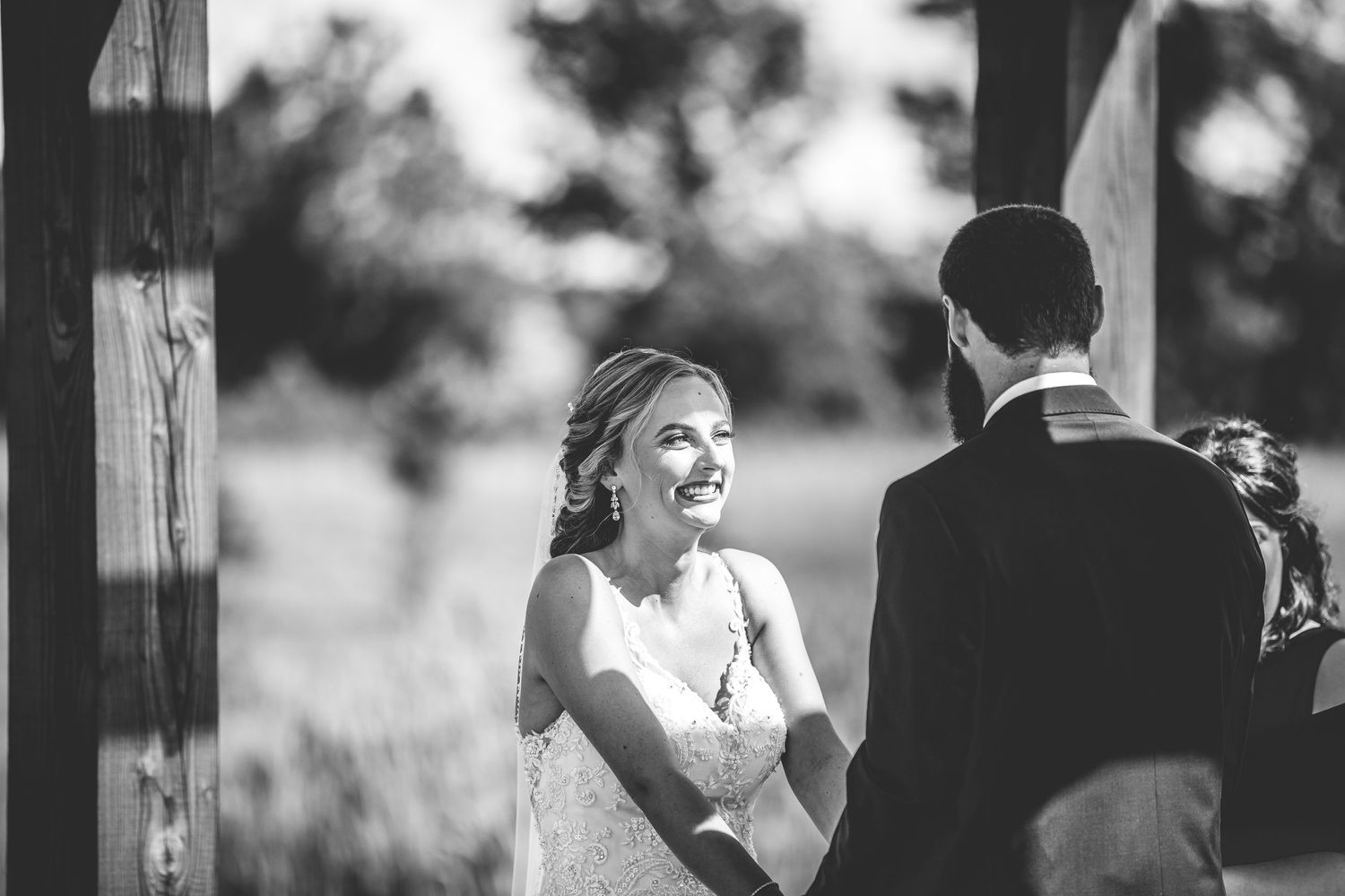Black and white capture of joyful moments during an outdoor wedding ceremony.