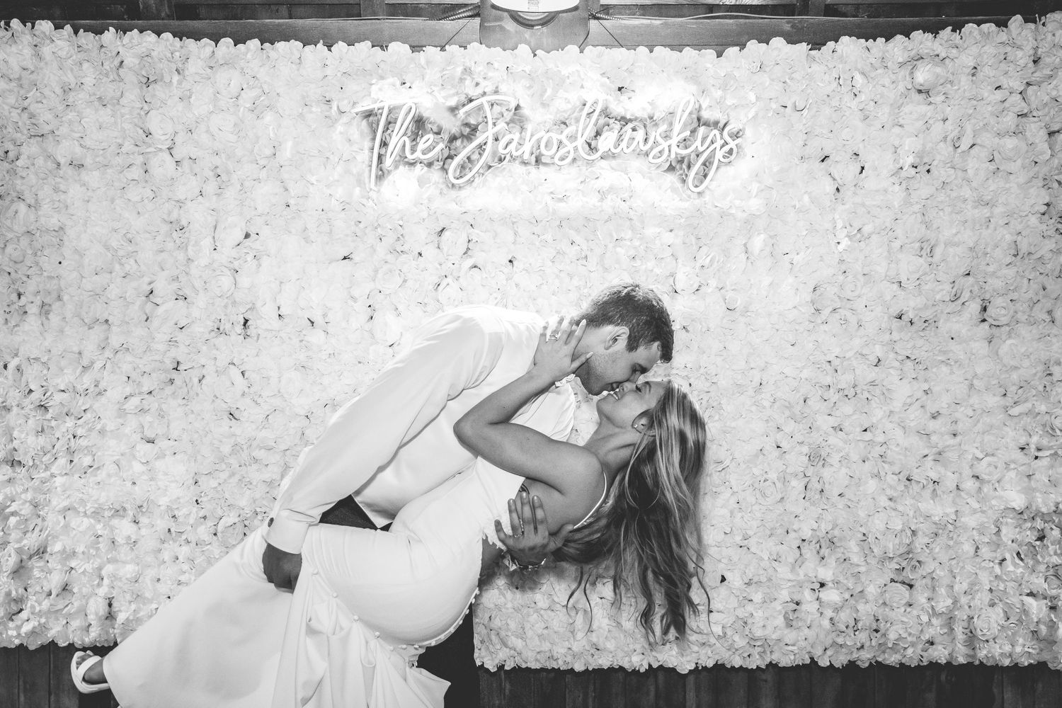 A romantic black and white photo of a couple dancing at their wedding reception.