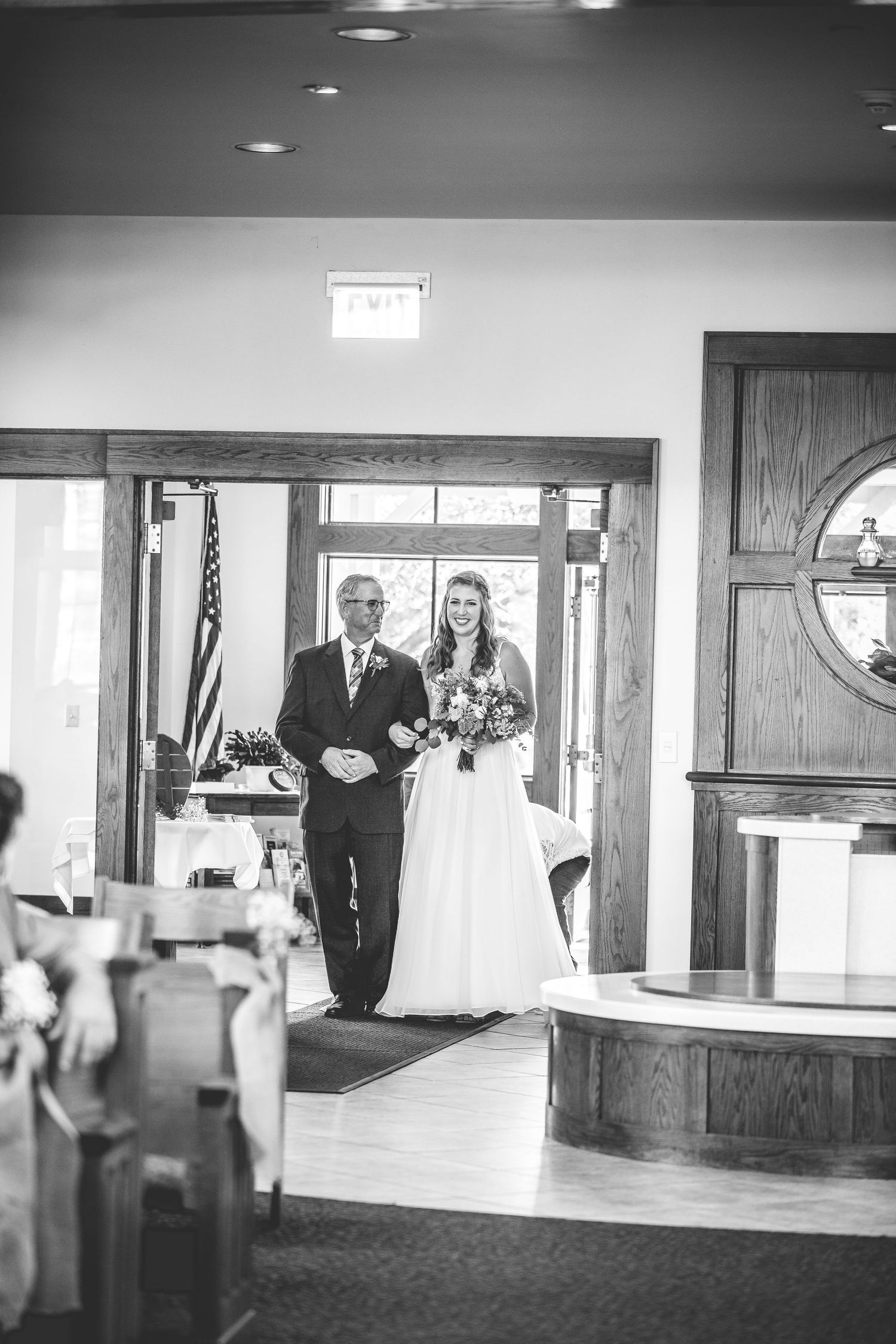 Black and white photo of church interior with wooden details and reception desk.
