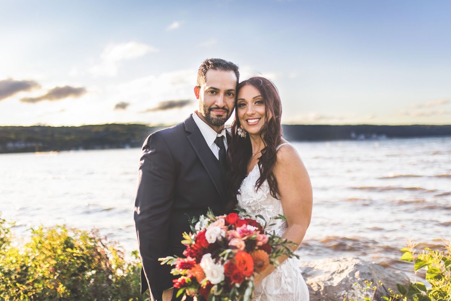 Romantic sunset beach wedding portraits with ocean waves in background.