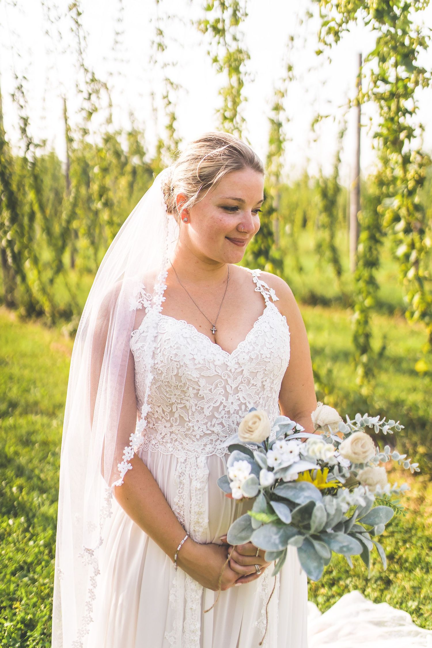 Elegant bridal portraits with a soft white and blue bouquet in a rustic farm setting.