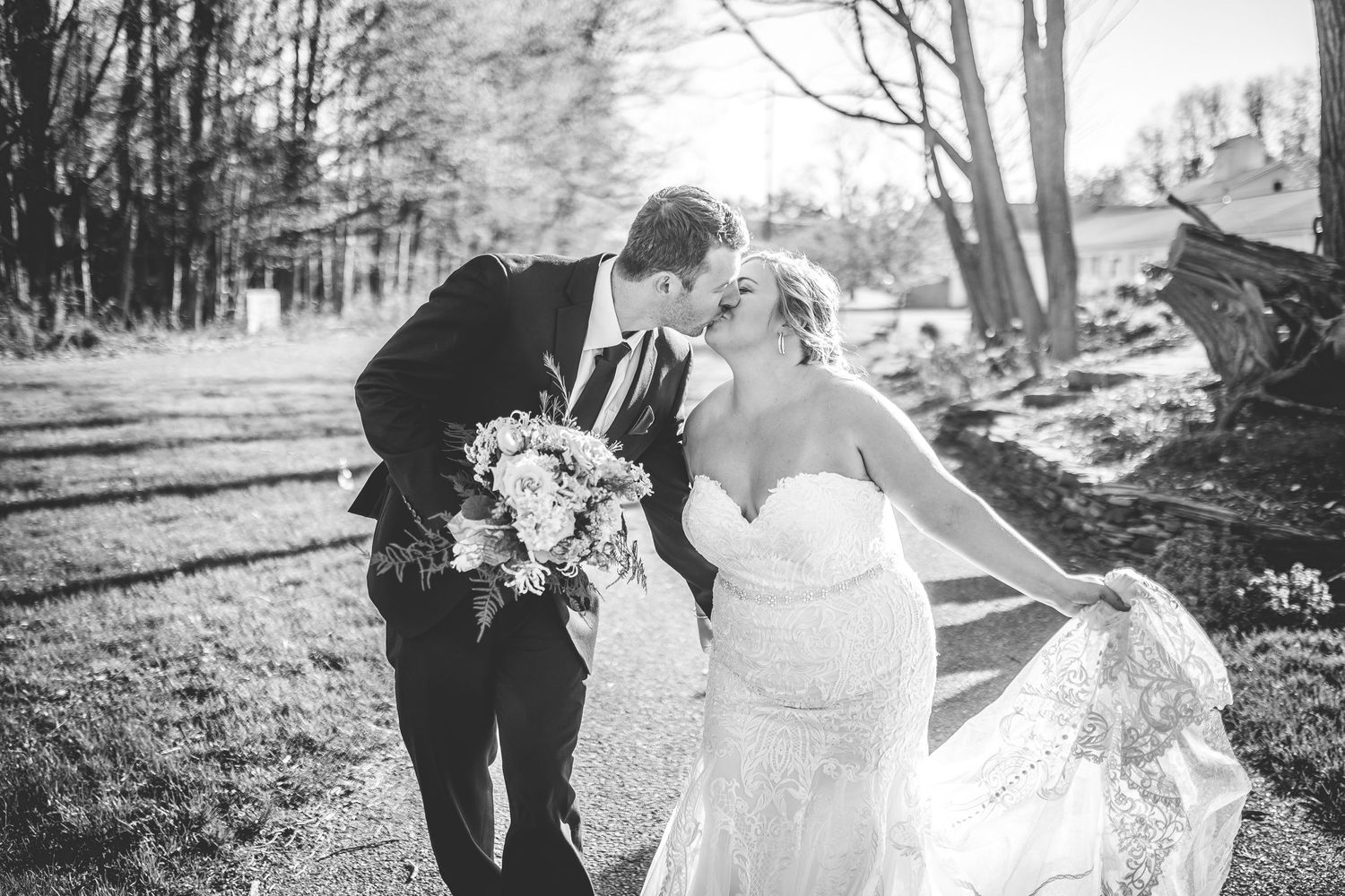 Black and white wedding portraits capture romantic moments between newlyweds in a wooded setting.