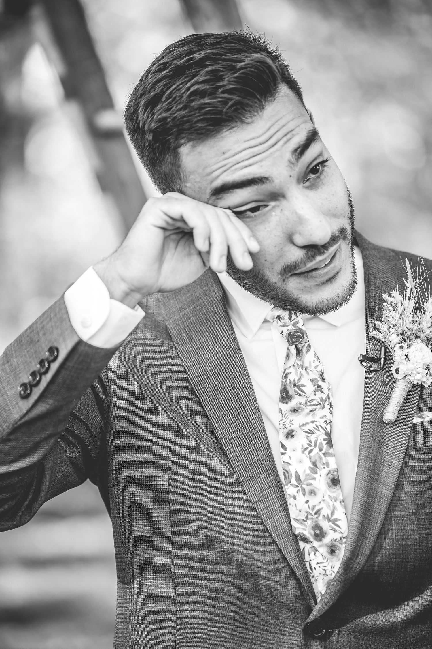 A black and white portrait shows an emotional moment during a wedding ceremony.