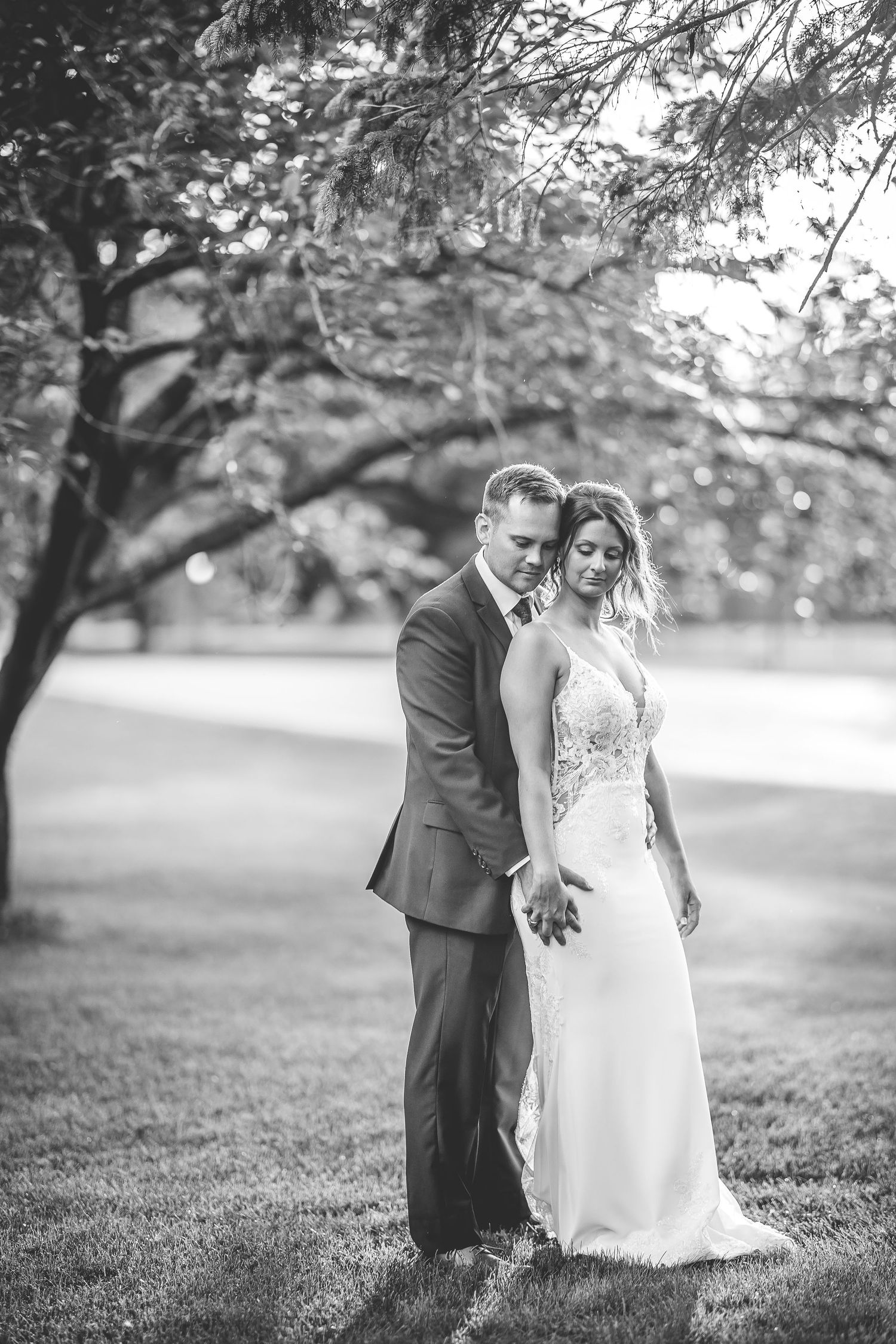 Black and white wedding portraits showing intimate moments on grassy lawn.