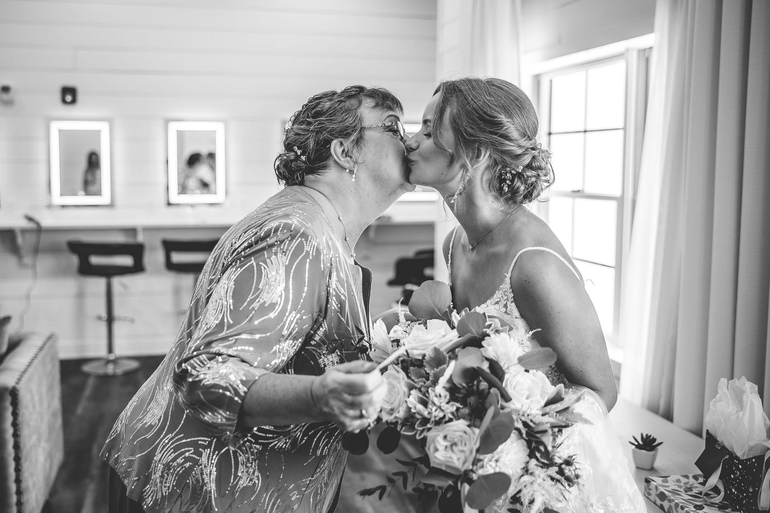 A wedding party gets ready in a bright white room with natural lighting.