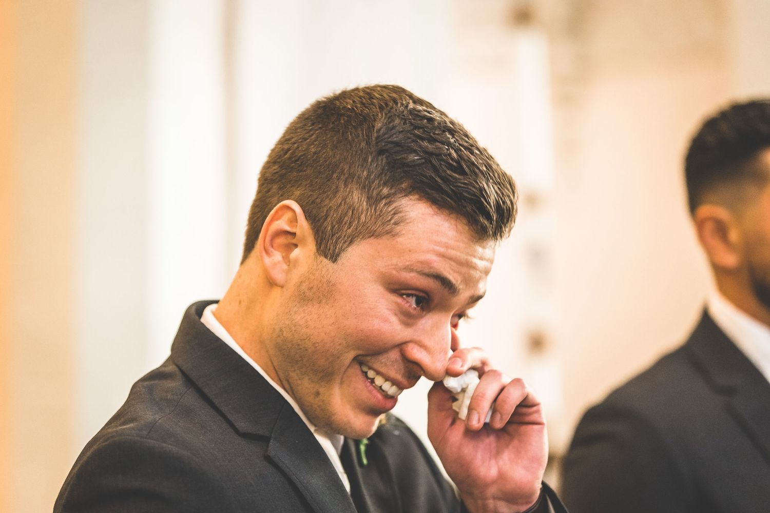Emotional wedding moment captured in warm lighting at an indoor ceremony.