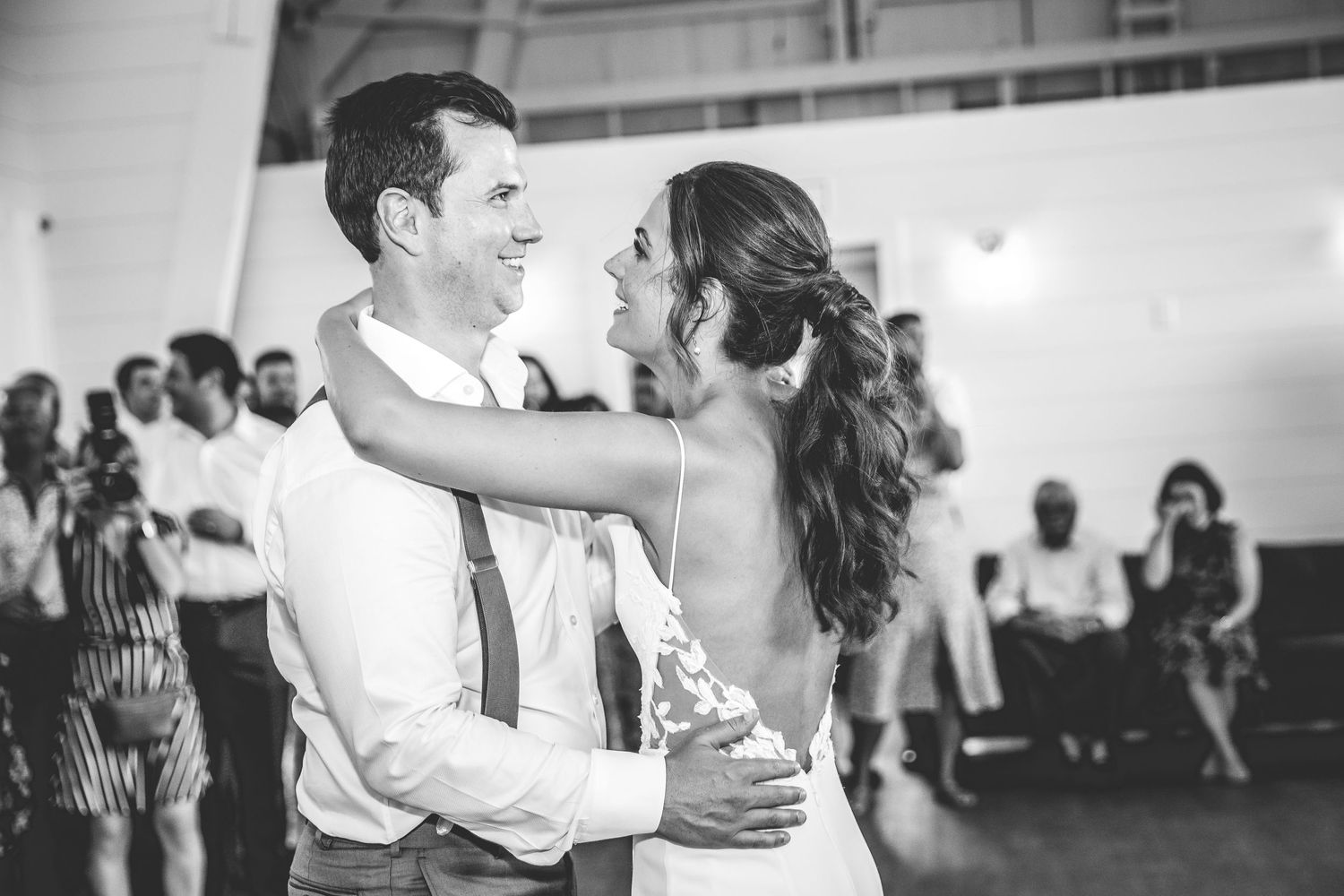 Couples dancing together during a wedding reception in a spacious indoor venue.