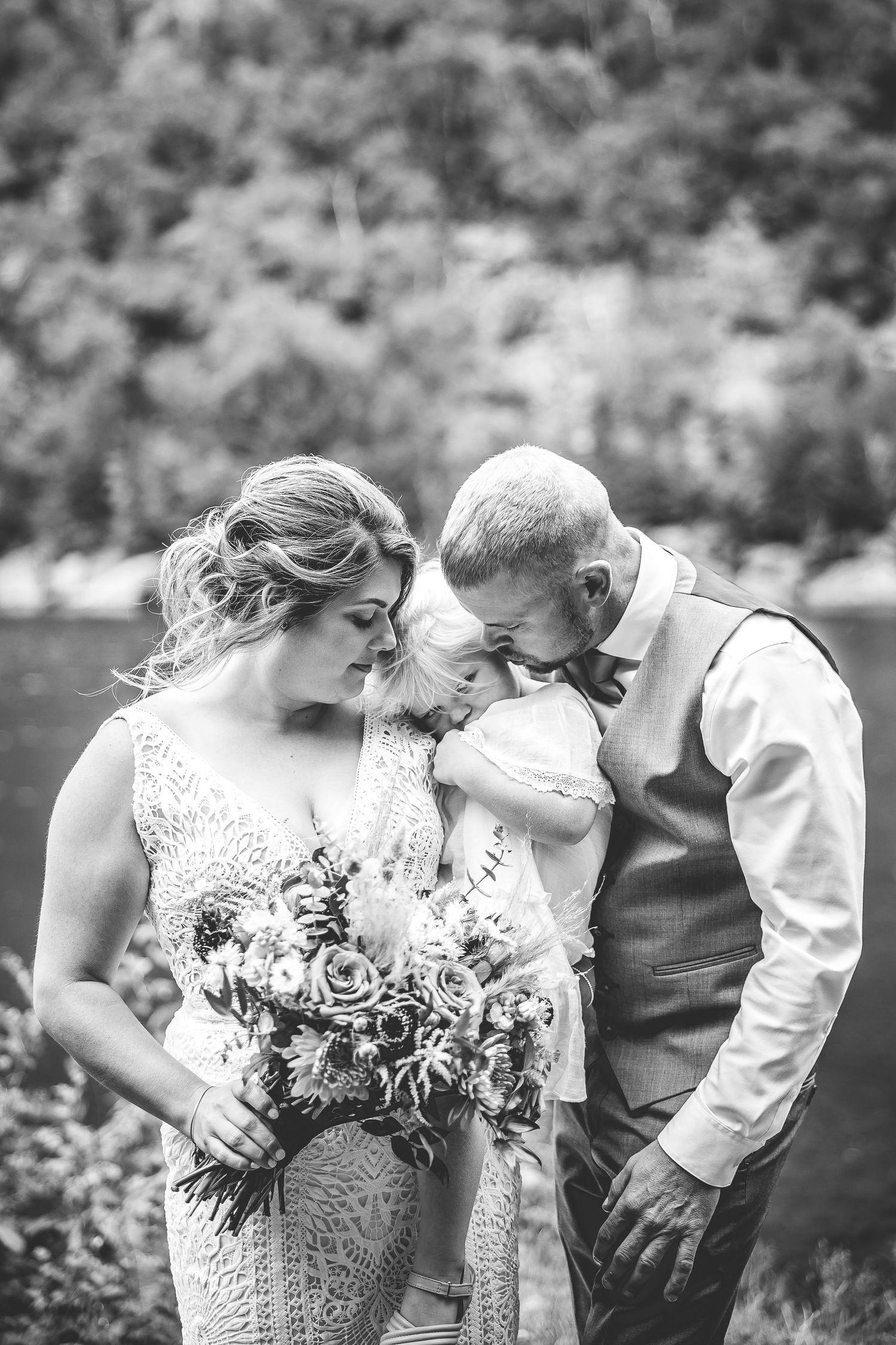 Intimate black and white wedding moment captured by mountain lake.