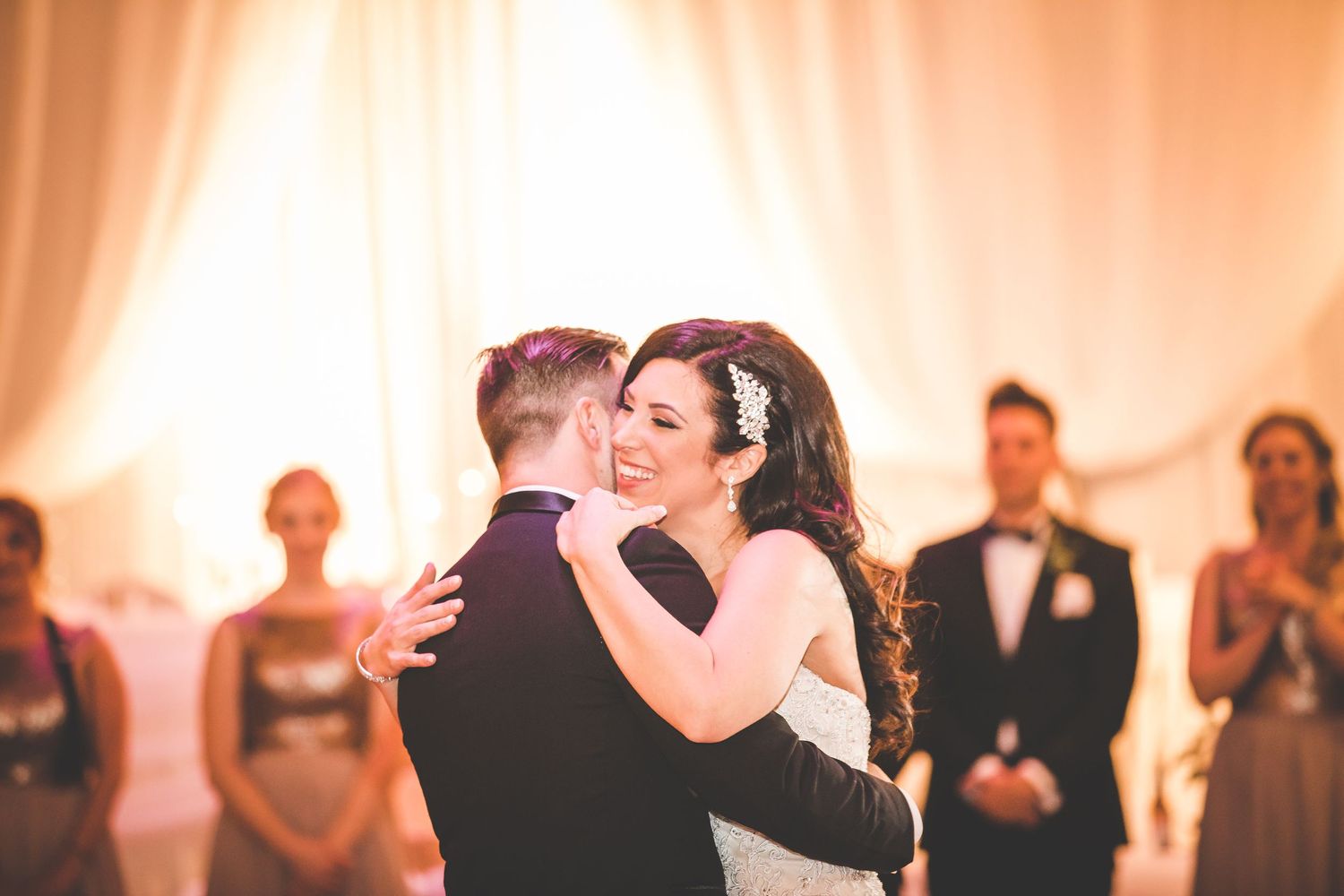 Wedding reception dance floor filled with guests celebrating under warm lighting.