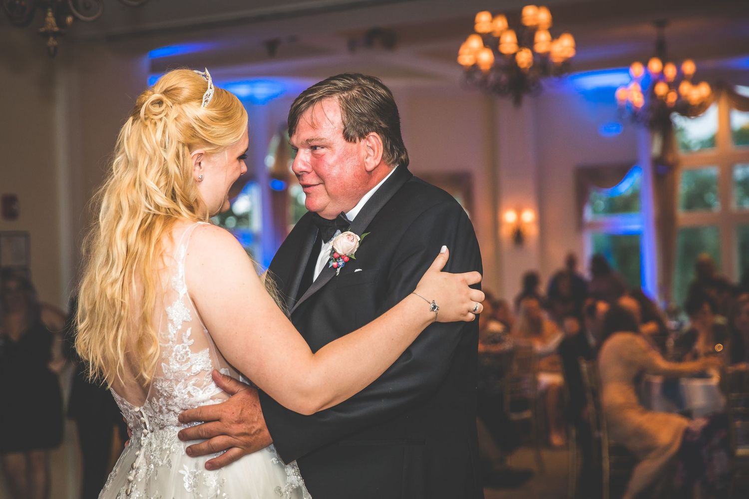Romantic dance moment captured in warm lighting at an elegant wedding reception venue.