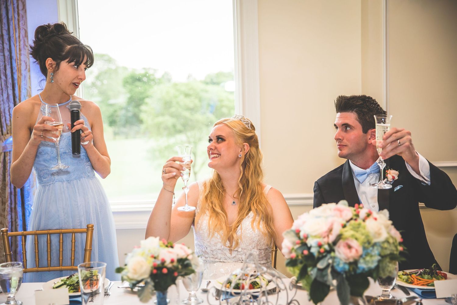 Wedding reception guests dining and socializing at decorated banquet tables.