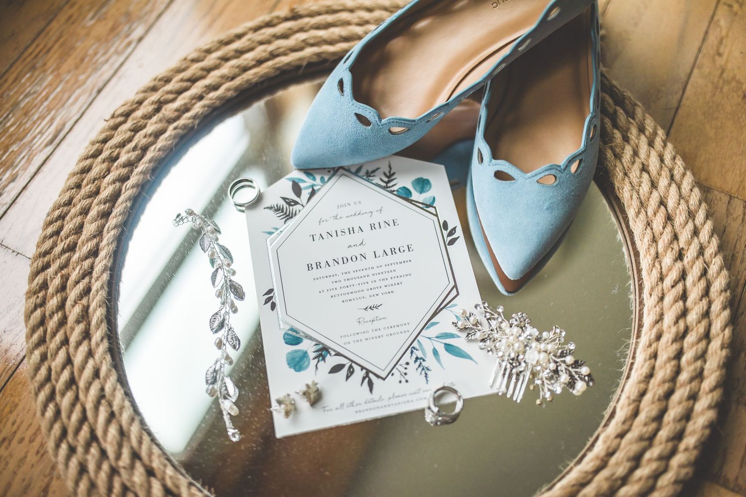 Elegant blue and white wedding invitations arranged on a circular rope placemat.