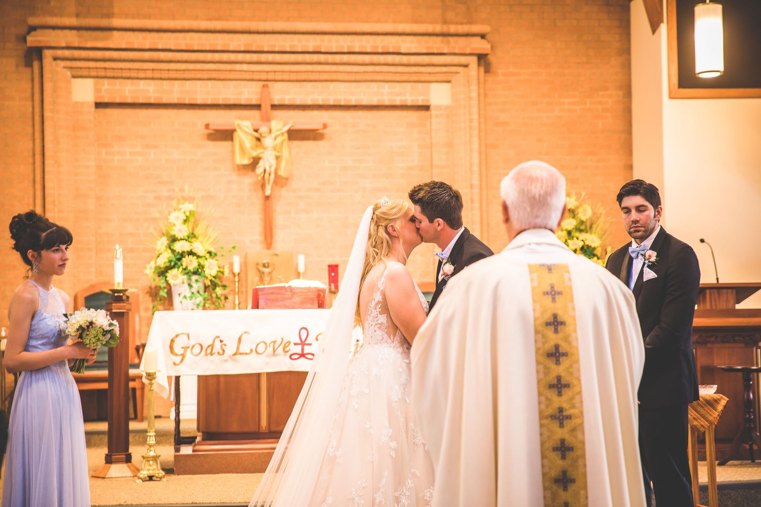 Traditional church wedding ceremony with stained glass windows and floral decorations.
