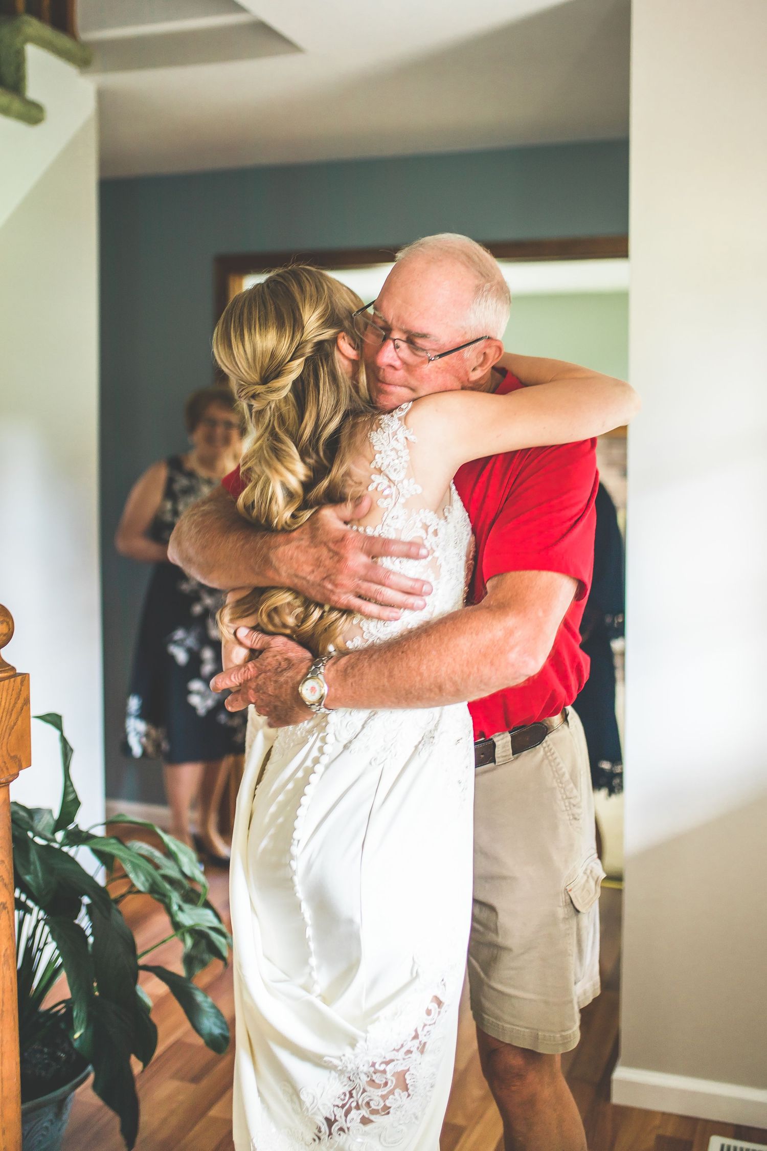 Emotional wedding day embraces in a bright indoor setting.