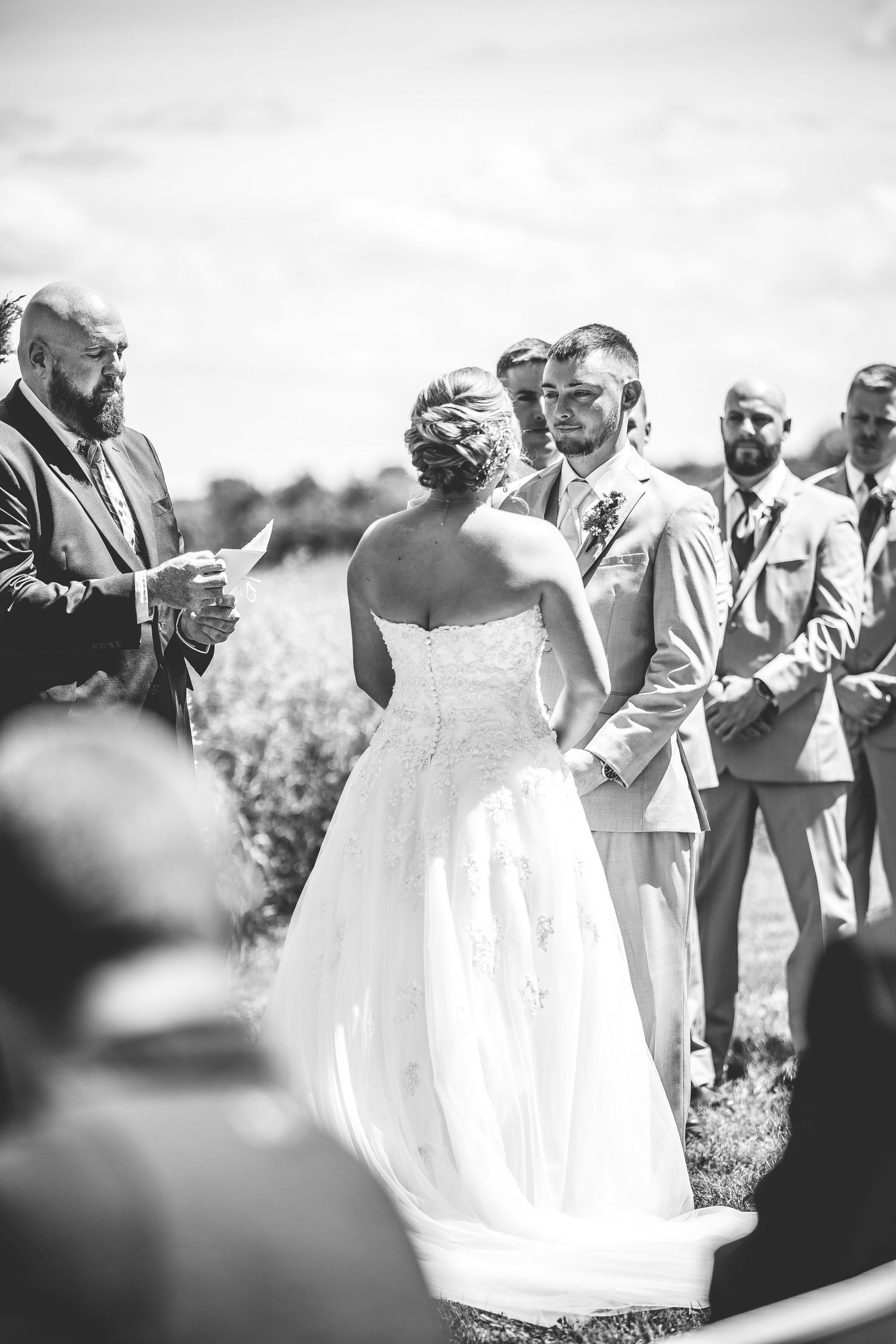 Black and white photo of wedding ceremony moment in an outdoor garden setting.