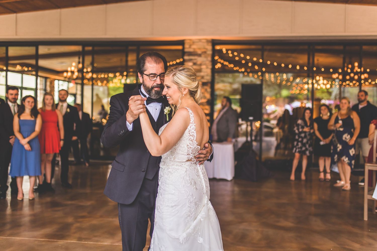 Wedding celebration in spacious venue with rustic decor and ambient lighting.