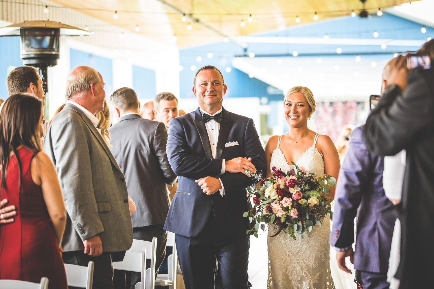 Wedding celebration in a bright venue with wooden ceiling beams and elegant decorations.