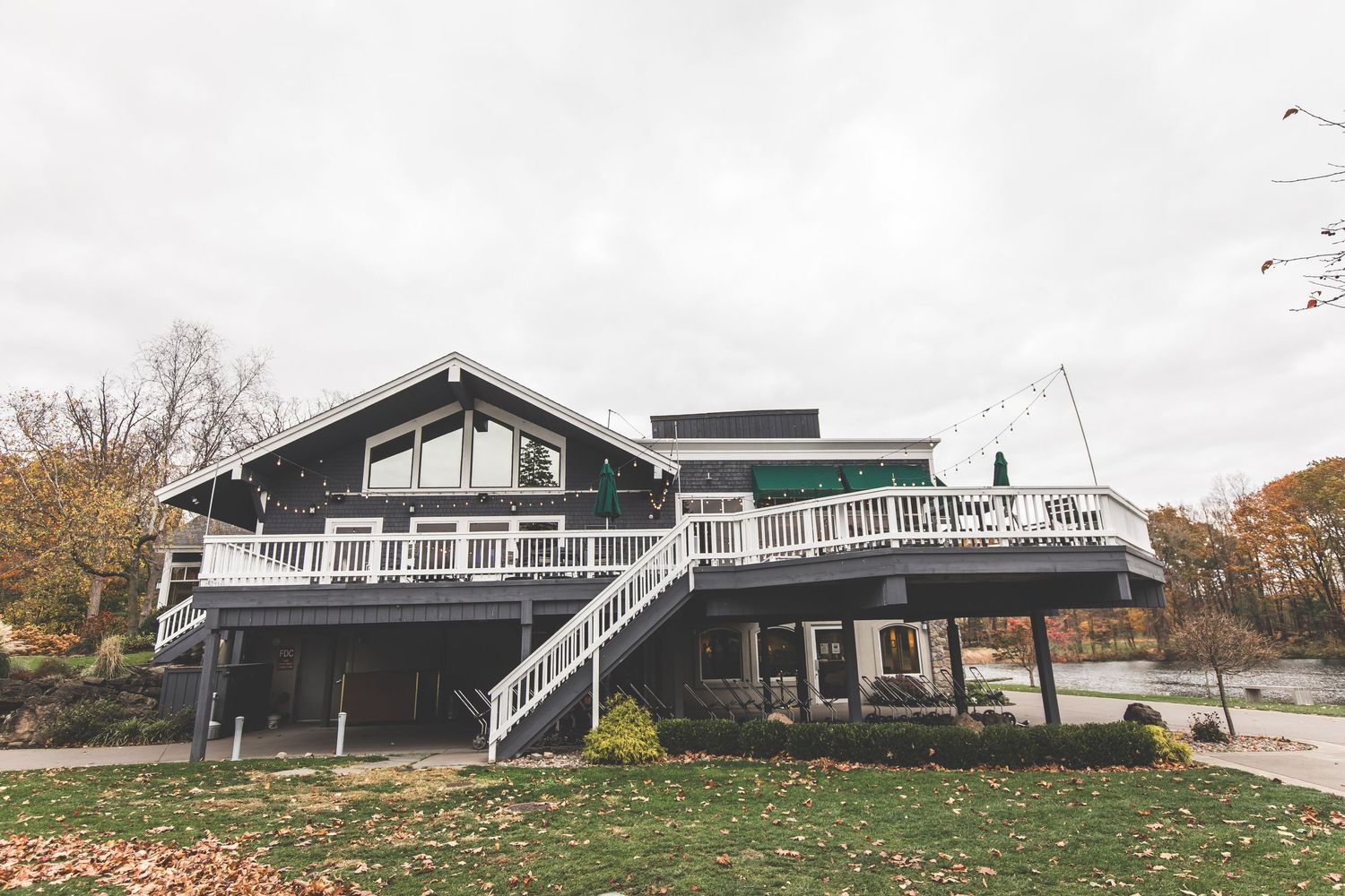 Panoramic view of lakeside houses with white railings during autumn season.