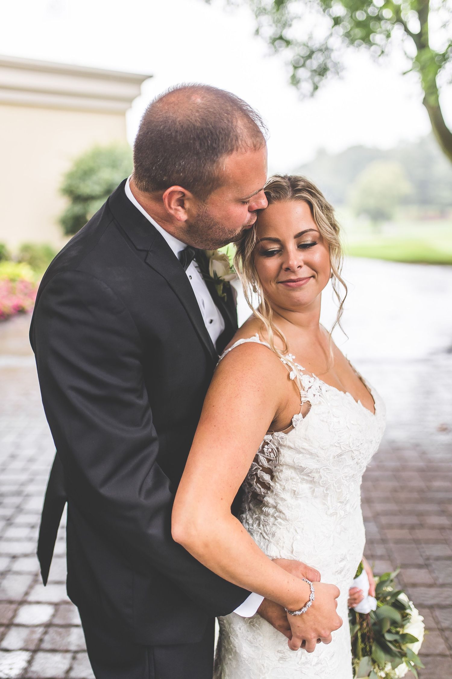 Romantic wedding portraits on cobblestone path showing tender moments between newlyweds.