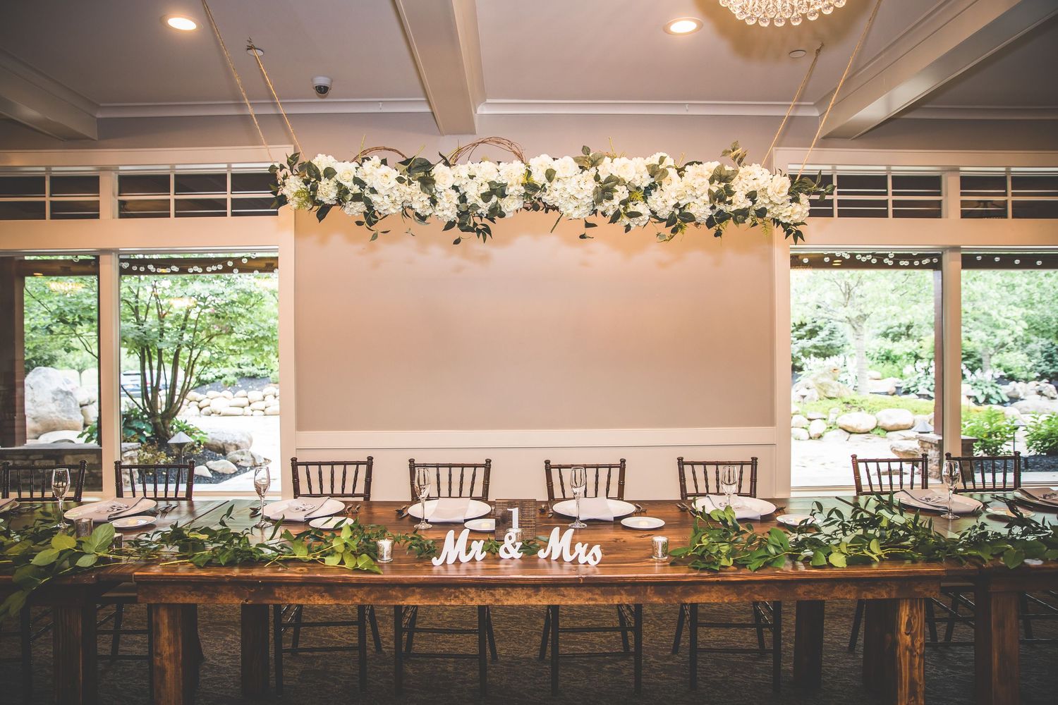 Modern wedding reception venue decorated with elegant chandeliers and floral arrangements.