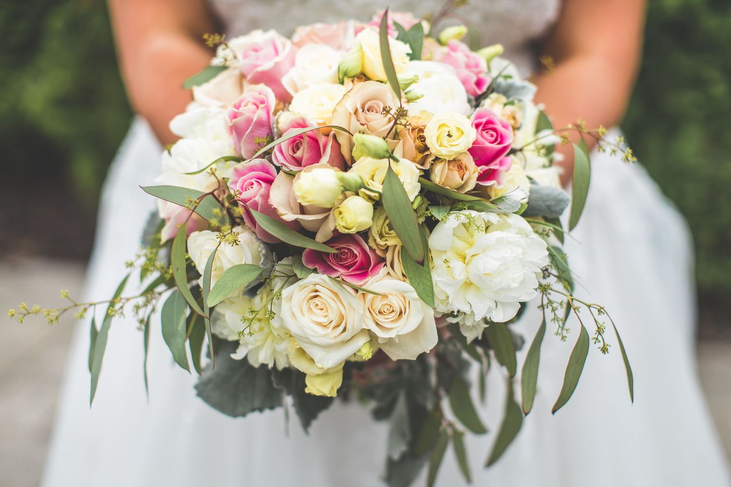 A stunning bridal bouquet with pink and white roses mixed with eucalyptus leaves.