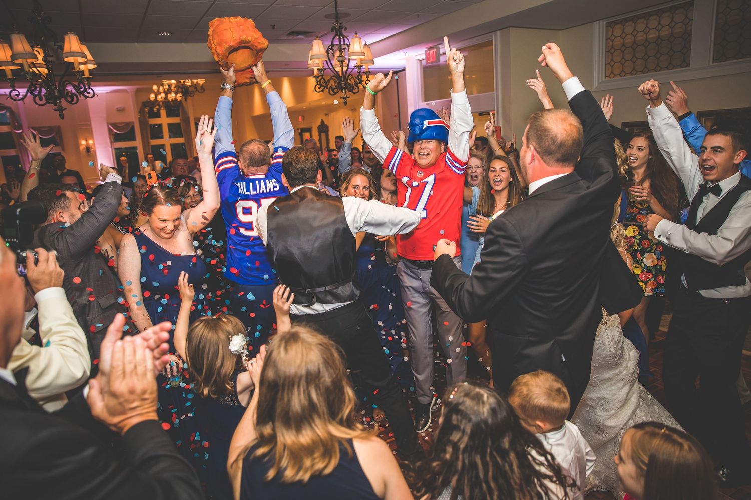Energetic dance party with guests in sports jerseys and formal attire.